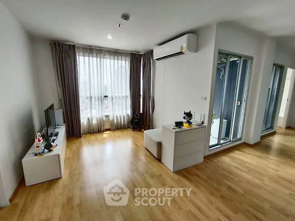 Spacious modern living room with wooden flooring and large window