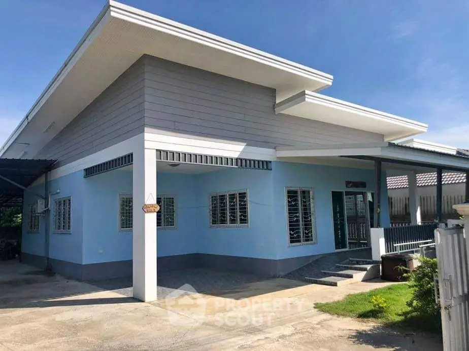 Modern single-story house with blue exterior and unique roof design
