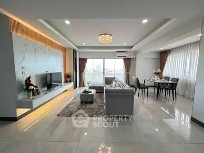 Spacious modern living room with elegant decor and large windows offering a stunning view.