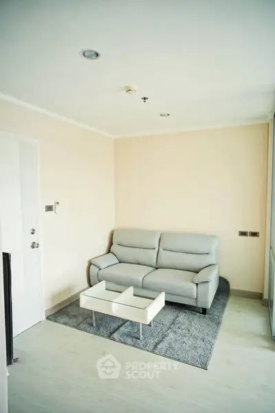 Modern living room with sleek sofa and glass coffee table on stylish rug