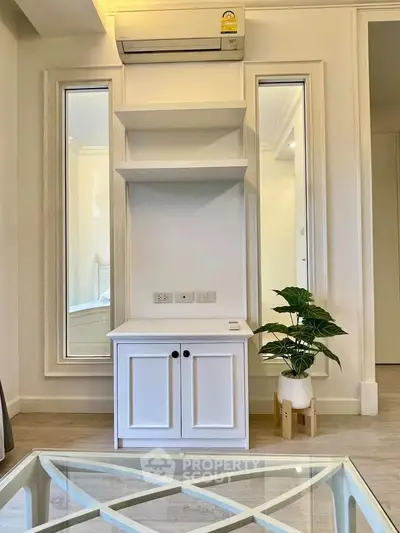 Modern living room with stylish white cabinet and air conditioning unit.