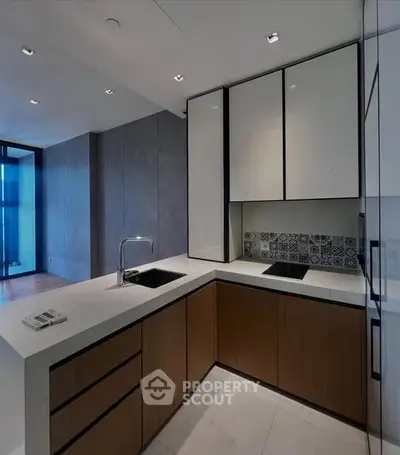 Modern kitchen with sleek cabinetry and stylish backsplash in a contemporary apartment.