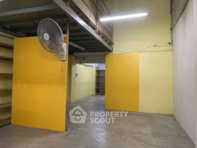Spacious industrial storage space with high ceilings and shelving units.