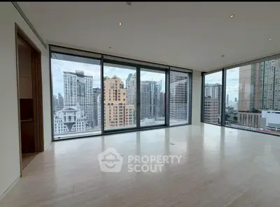 Spacious modern living room with floor-to-ceiling windows offering stunning city views.