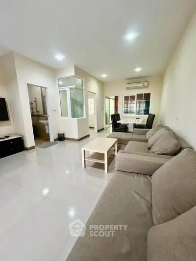 Spacious living room with modern furniture and open layout, perfect for relaxation and entertainment.