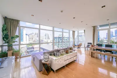 Spacious modern living room with panoramic city views and elegant decor.