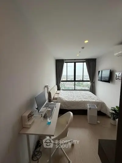 Modern bedroom with workspace and city view, featuring sleek design and natural light.