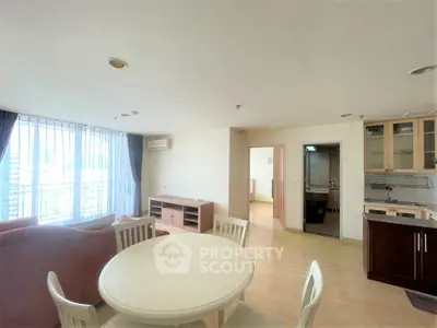 Spacious open-plan living room with dining area and modern kitchen in a bright apartment.