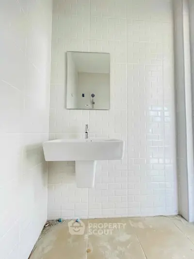 Minimalist bathroom with white subway tiles and modern sink design.
