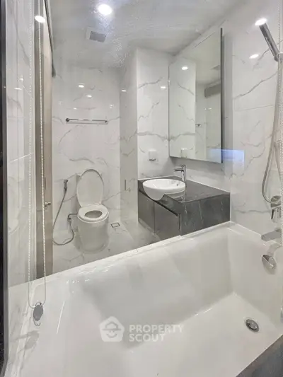 Modern bathroom with sleek marble tiles and bathtub in luxury apartment