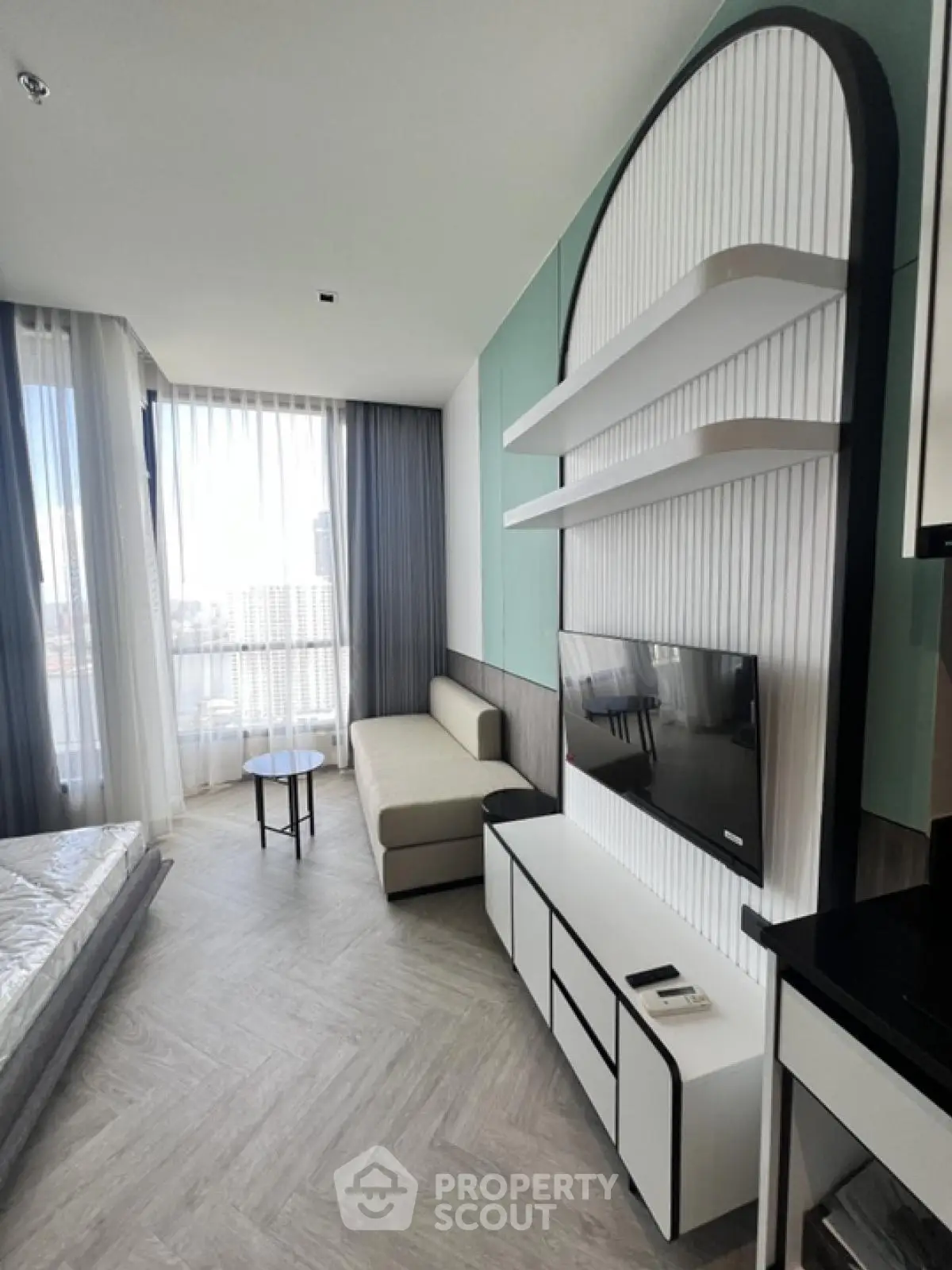 Modern living room with sleek furniture and large windows offering natural light