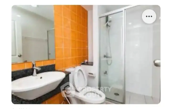 Modern bathroom with orange tiles and glass shower enclosure