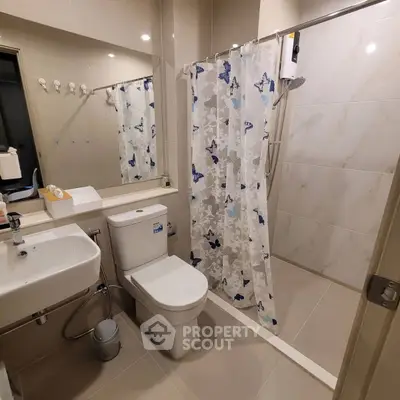 Modern bathroom with shower curtain and sleek fixtures in a contemporary apartment.