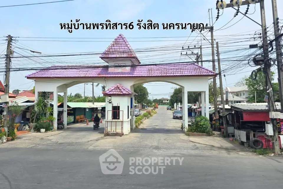 Charming residential entrance with purple roof in serene neighborhood setting.