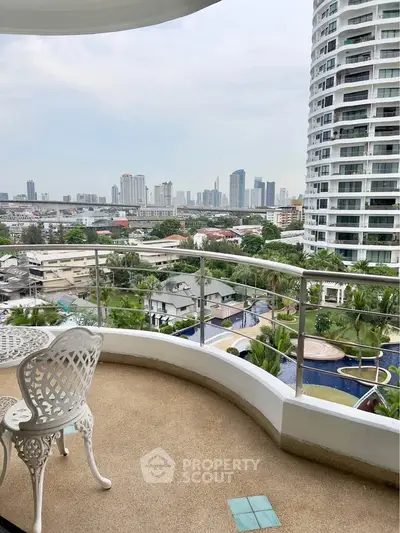 Stunning balcony view of city skyline and pool, perfect for relaxation.