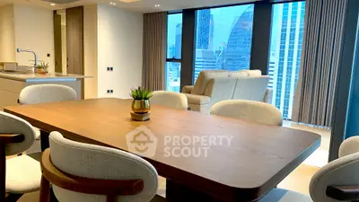 Modern open-plan living and dining area with city view, featuring elegant furniture and natural light.