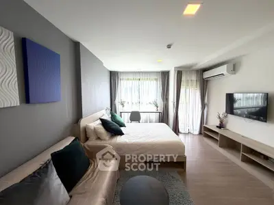 Modern bedroom with stylish decor, large window, and wall-mounted TV in a cozy apartment.