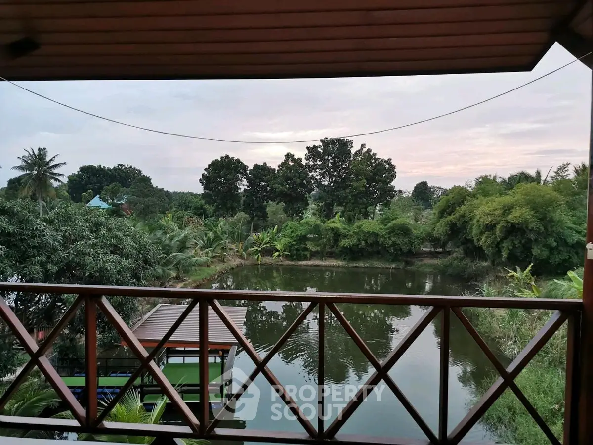 Scenic balcony view overlooking lush greenery and tranquil water body, perfect for nature lovers.
