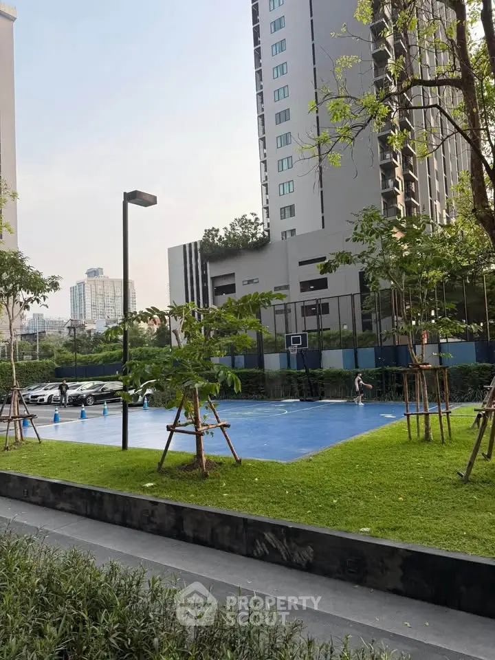 Modern residential complex with lush green garden and outdoor sports court