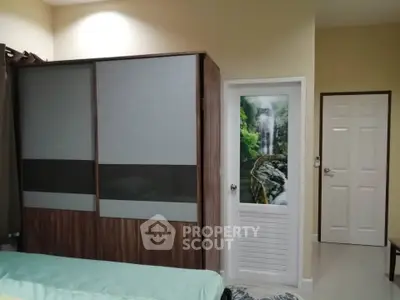 Cozy bedroom with modern wardrobe and unique waterfall-themed door