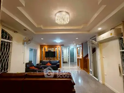 Spacious living room with elegant chandelier and leather sofas