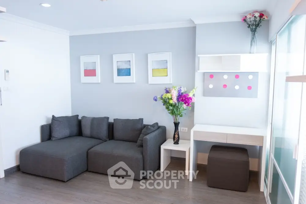 Modern living room with stylish gray sofa and vibrant floral decor
