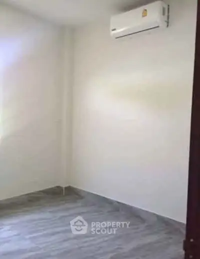 Minimalist empty room with air conditioning and sleek flooring, perfect for customization.