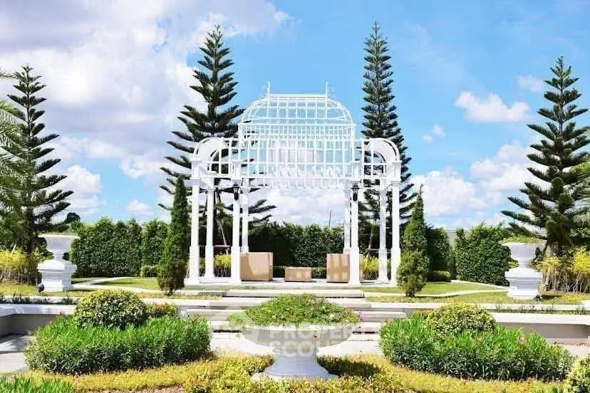 Elegant garden with white pergola and lush greenery, perfect for outdoor relaxation and events.