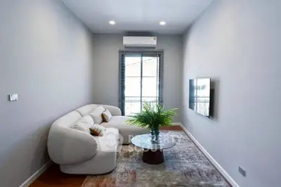 Modern living room with cozy sofa, wall-mounted TV, and stylish decor in a bright, airy space.