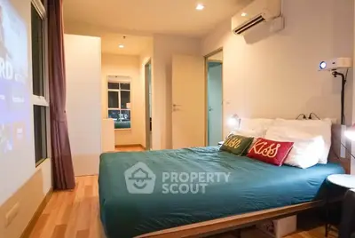 Modern bedroom with cozy decor and projector, featuring hardwood floors and ambient lighting.