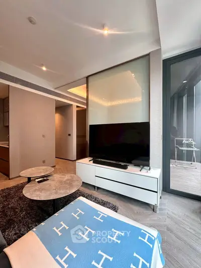 Modern living room with stylish decor and large TV, featuring sleek furniture and elegant design.