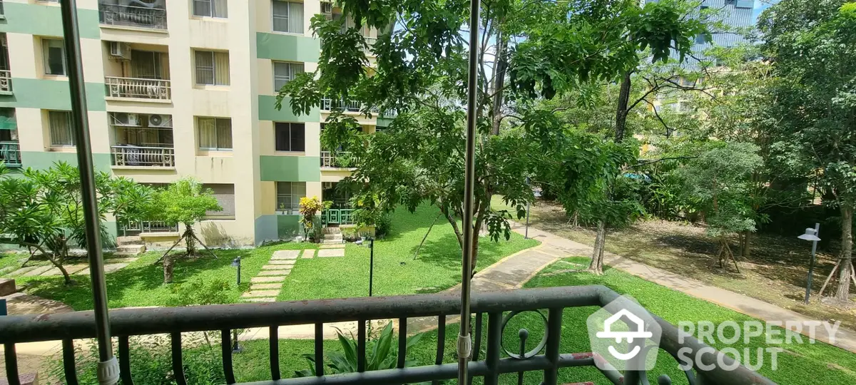 Serene balcony view overlooking lush green communal garden in a tranquil residential complex, perfect for relaxation and nature lovers.