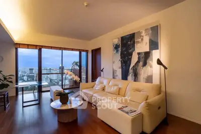 Luxurious living room with stunning city view, elegant decor, and cozy seating area.