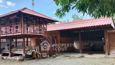 Charming traditional wooden house with elevated balcony and spacious outdoor area.