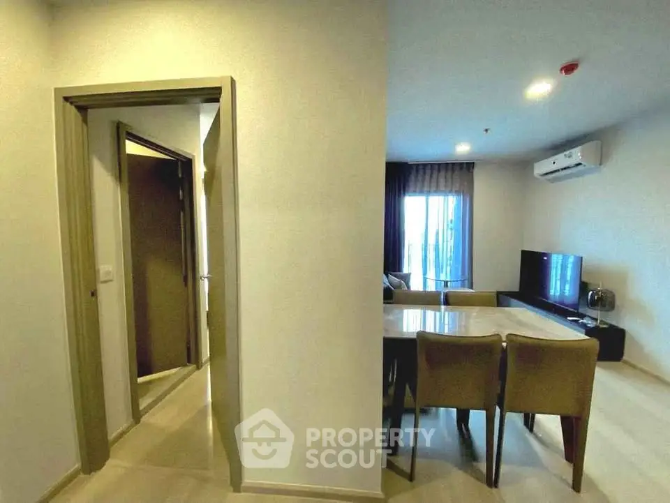Modern living room with dining area and air conditioning in a stylish apartment.