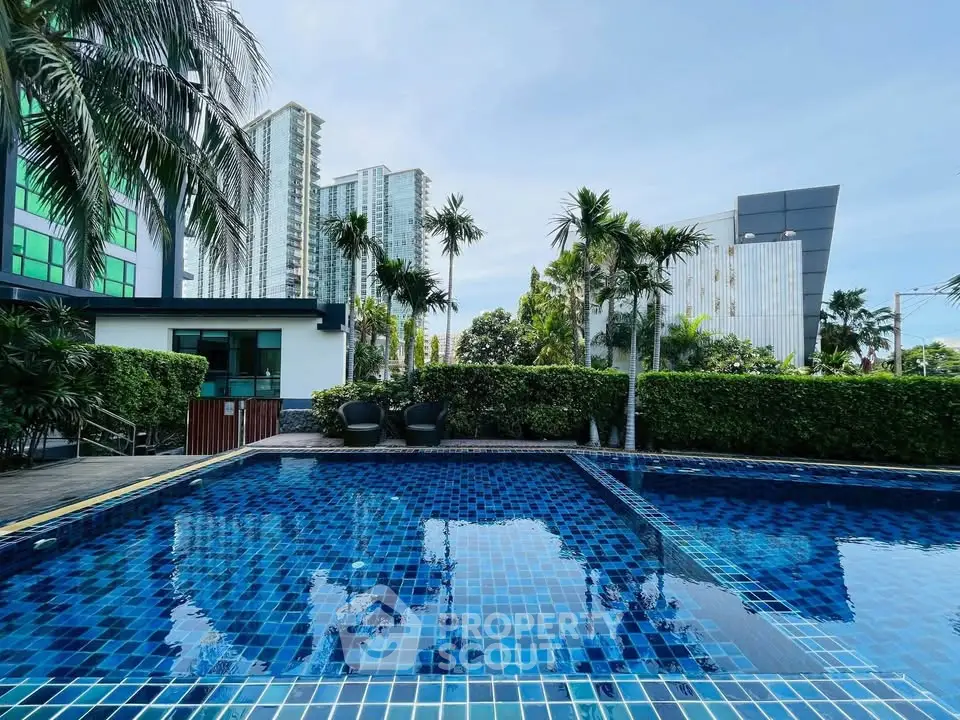 Luxurious condominium pool with city skyline view and lush greenery.