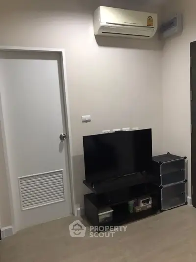 Modern living room with sleek TV stand and air conditioning unit, perfect for cozy urban living.