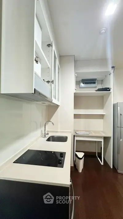 Modern kitchen with sleek countertops and built-in appliances in a compact layout.