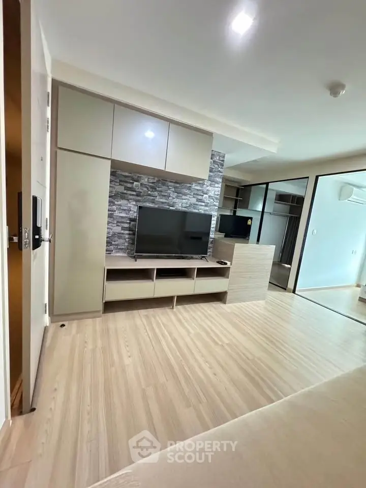 Modern living room with sleek TV unit and wood flooring