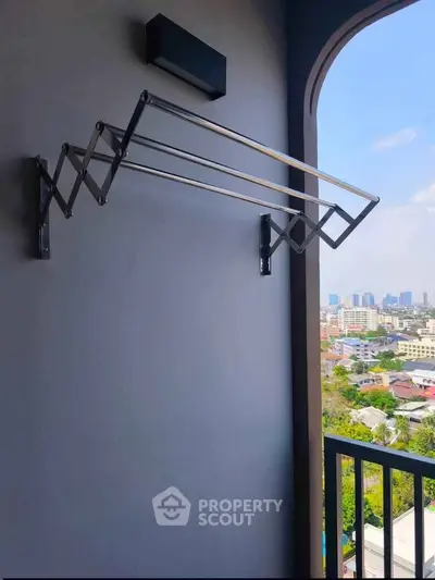 Modern balcony with city view and retractable clothes drying rack.