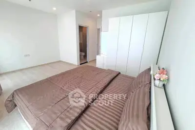 Spacious bedroom with modern decor and ample natural light, featuring a cozy bed and sleek wardrobe.