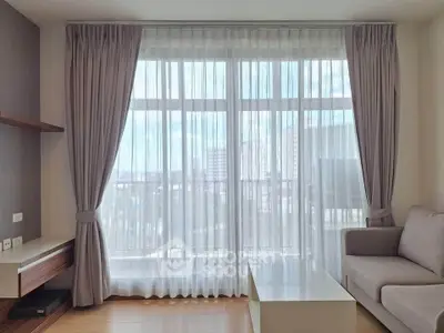 Bright and airy living room with large windows and modern furnishings in a stylish apartment.