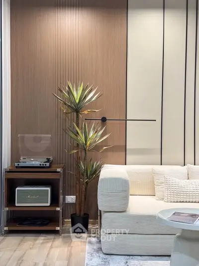 Modern living room with stylish decor, featuring a cozy sofa, elegant wall paneling, and a vintage record player.