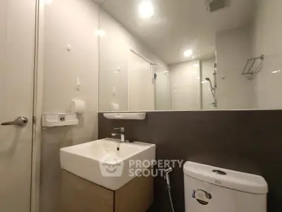 Modern bathroom with sleek sink and toilet in contemporary design.