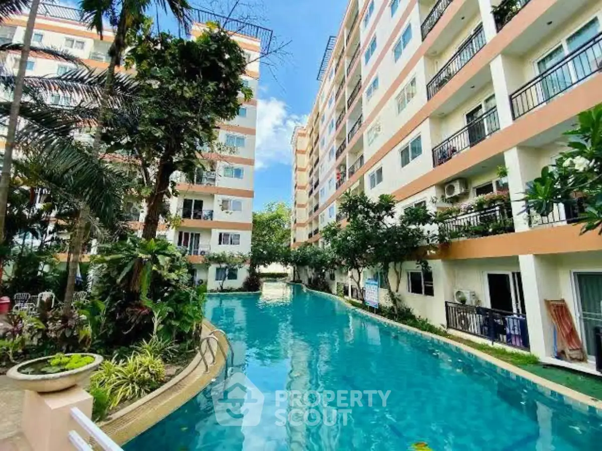 Stunning residential complex with a large swimming pool and lush greenery.
