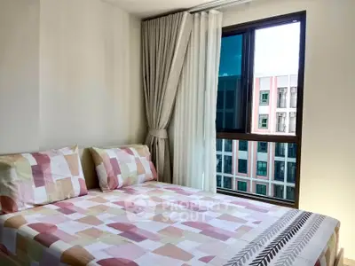 Bright bedroom with modern decor and large window offering city view
