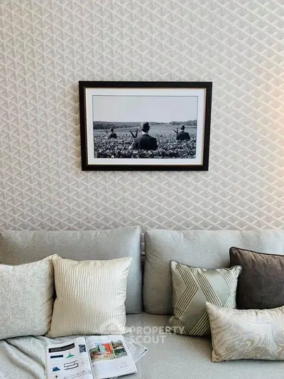 Stylish living room with modern decor and cozy sofa, featuring elegant wall art and patterned cushions.