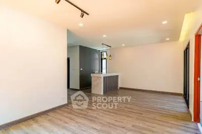 Spacious open-plan living area with modern flooring and stylish lighting.