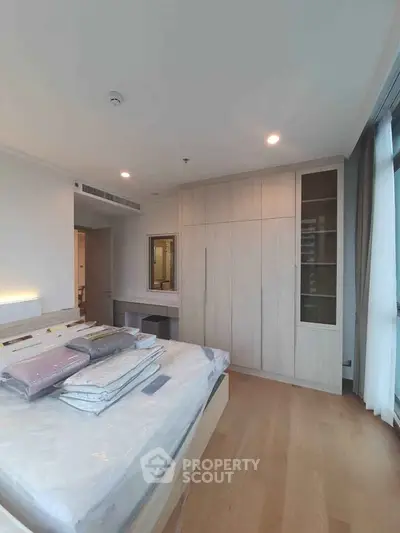 Spacious bedroom with modern design and ample natural light, featuring built-in wardrobe and cozy ambiance.
