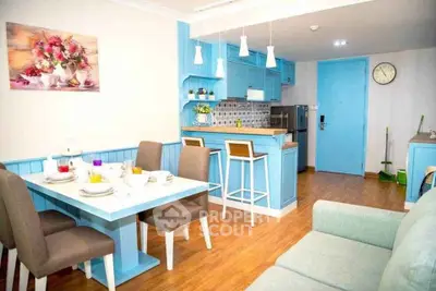 Charming open-layout kitchen and dining area with pastel blue cabinetry and modern decor.